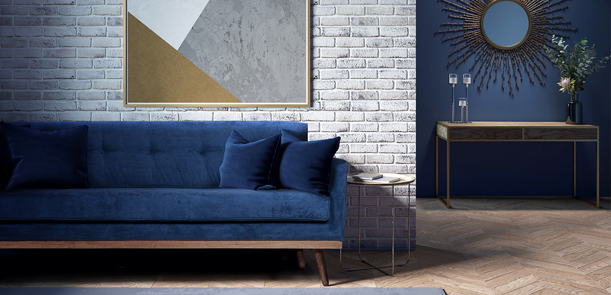 Granatowa sofa w stylu skandynawskim stoi w salonie